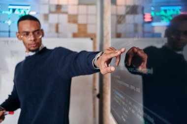 Afrikalı Amerikalı iş adamı iş stratejisini meslektaşlarına sunuyor, işbirliğini ve ileriyi düşünmeyi teşvik ediyor..