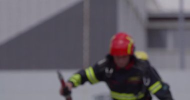 İtfaiyecilerden oluşan özel bir ekip bir itfaiye aracından hortumları alıyor ve tehlikeli bir tehlikeyle mücadele etmedeki cesaret ve profesyonel uzmanlıklarını sergileyerek, yanan bir yangını söndürmek için tehlikeli bir göreve çıkıyorlar.