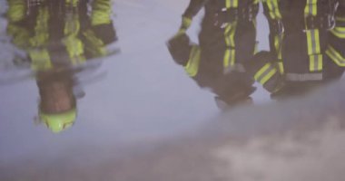 Sudaki yansıma gösteriyor ki, özel donanımlı itfaiyecilerden oluşan bir ekip zor durumdaki insanları kurtarmak için yüksek riskli ve hayat kurtaran bir göreve çıkıyor.