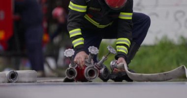 İtfaiyecilerden oluşan özel bir ekip bir itfaiye aracından hortumları alıyor ve tehlikeli bir tehlikeyle mücadele etmedeki cesaret ve profesyonel uzmanlıklarını sergileyerek, yanan bir yangını söndürmek için tehlikeli bir göreve çıkıyorlar.