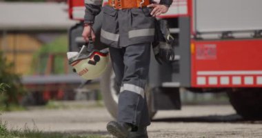 İtfaiye arabasının yanında duran özel bir itfaiye eri tehlikeli yangın senaryolarında yüksek riskli bir kurtarma görevine hazırlanıyor. Acil durumlarda hayat kurtarmaya kararlı olduğunu gösteriyor.