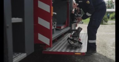 Profesyonel bir itfaiyeci tehlikeli metal kesme ekipmanlarını itfaiye aracında titizlikle hazırlar ve acil durumlarda yüksek riskli kurtarma operasyonlarına hazır olduklarını gösterir..