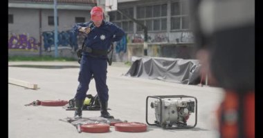 İtfaiyecilerden oluşan özel bir ekip bir itfaiye aracından hortumları alıyor ve tehlikeli bir tehlikeyle mücadele etmedeki cesaret ve profesyonel uzmanlıklarını sergileyerek, yanan bir yangını söndürmek için tehlikeli bir göreve çıkıyorlar.