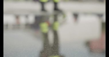 Bir itfaiyecinin kararlı adımlarını yakına çekerek itfaiye aracına doğru yürürken sarsılmaz bir adanmışlıkla acil bir duruma müdahale etmeye hazır olduğunu gösterir.. 
