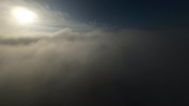 Dağlarda taze bir sabahta inanılmaz güzel bir bulutun içinden uçmak. Beyaz tüylü bulutlardan oluşan FPV insansız hava aracı açık mavi gökyüzünde usulca hareket ediyor