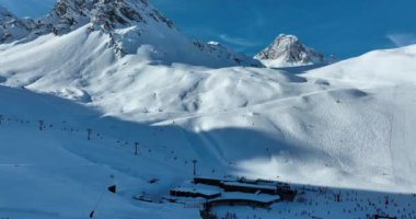 Tignes, Valdisere Fransa 'da kar ile kaplı kayak tabancaları ve yamaçlarının kış drone çekimi. Güneşli bir günde Alpler 'in panoramik manzarası güzel bir kayak kaldırışı snowboard ve kayak merkezlerinde