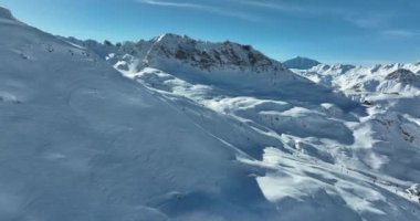 Tignes, Valdisere Fransa 'da kar ile kaplı kayak tabancaları ve yamaçlarının kış drone çekimi. Güneşli bir günde Alpler 'in panoramik manzarası güzel bir kayak kaldırışı snowboard ve kayak merkezlerinde