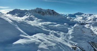 Tignes, Valdisere Fransa 'da kar ile kaplı kayak tabancaları ve yamaçlarının kış drone çekimi. Güneşli bir günde Alpler 'in panoramik manzarası güzel bir kayak kaldırışı snowboard ve kayak merkezlerinde