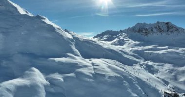 Tignes, Valdisere Fransa 'da kar ile kaplı kayak tabancaları ve yamaçlarının kış drone çekimi. Güneşli bir günde Alpler 'in panoramik manzarası güzel bir kayak kaldırışı snowboard ve kayak merkezlerinde