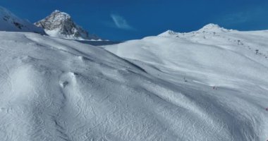 Tignes, Valdisere Fransa 'da kar ile kaplı kayak tabancaları ve yamaçlarının kış drone çekimi. Güneşli bir günde Alpler 'in panoramik manzarası güzel bir kayak kaldırışı snowboard ve kayak merkezlerinde