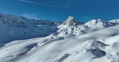 Tignes, Valdisere Fransa 'da kar ile kaplı kayak tabancaları ve yamaçlarının kış drone çekimi. Güneşli bir günde Alpler 'in panoramik manzarası güzel bir kayak kaldırışı snowboard ve kayak merkezlerinde