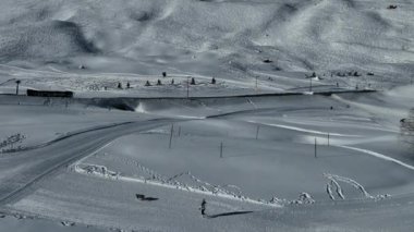 Tignes, Valdisere Fransa 'da kar ile kaplı kayak tabancaları ve yamaçlarının kış drone çekimi. Güneşli bir günde Alpler 'in panoramik manzarası güzel bir kayak kaldırışı snowboard ve kayak merkezlerinde
