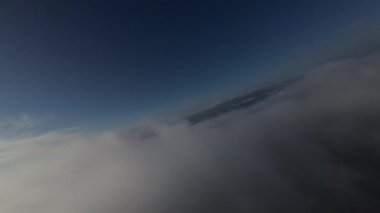 Taze bir yaz sabahı dağlarda muhteşem bir bulutlar arasında uçmak. Beyaz tüylü bulutlardan oluşan FPV insansız hava aracı açık mavi gökyüzünde usulca hareket ediyor