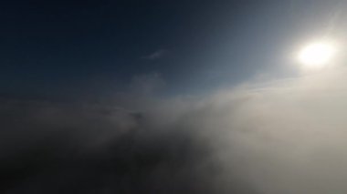 Taze bir yaz sabahı dağlarda muhteşem bir bulutlar arasında uçmak. Beyaz tüylü bulutlardan oluşan FPV insansız hava aracı açık mavi gökyüzünde usulca hareket ediyor