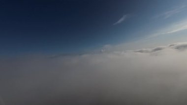 Taze bir yaz sabahı dağlarda muhteşem bir bulutlar arasında uçmak. Beyaz tüylü bulutlardan oluşan FPV insansız hava aracı açık mavi gökyüzünde usulca hareket ediyor