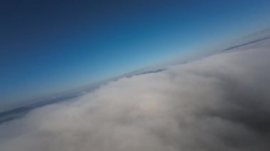 Taze bir yaz sabahı dağlarda muhteşem bir bulutlar arasında uçmak. Beyaz tüylü bulutlardan oluşan FPV insansız hava aracı açık mavi gökyüzünde usulca hareket ediyor