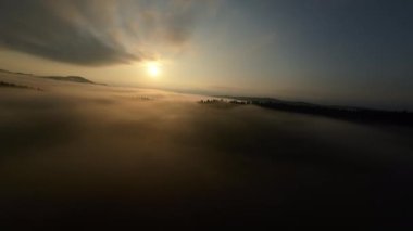 Puslu ormanda sabah sisli bir havada uçan hava aracı bulutların üzerinde gündoğumu rüyası konsepti