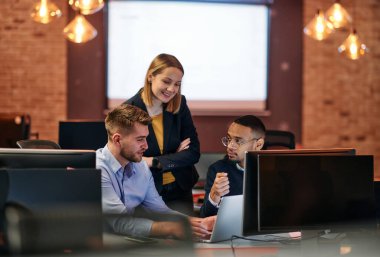 Çağdaş bir ofis ortamında, çeşitli iş adamları iş girişimlerini strateji haline getirmek ve planlamak için bilgisayarları kullanarak odaklanmış bir tartışmaya girişirler.. 