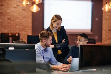 Çağdaş bir ofis ortamında, çeşitli iş adamları iş girişimlerini strateji haline getirmek ve planlamak için bilgisayarları kullanarak odaklanmış bir tartışmaya girişirler.. 
