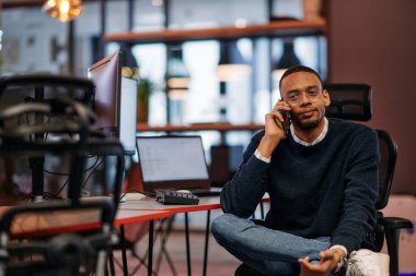 İşteki zorlu bir günden sonra, Afrikalı bir Amerikalı ofisinde teselliyi bulur, akıllı telefonunu kullanırken dinlenir ve düşünür.. 