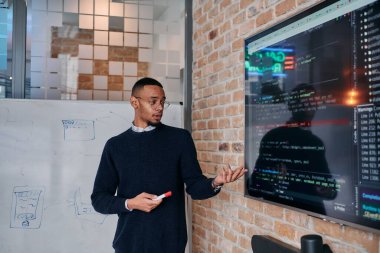 Afrikalı Amerikalı iş adamı iş stratejisini meslektaşlarına sunuyor, işbirliğini ve ileriyi düşünmeyi teşvik ediyor..