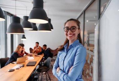Modern ofis ortamında, sarışın bir iş kadını, stratejik tartışmalar ve karar verme sürecinde meslektaşlarıyla bir toplantı düzenler.. 