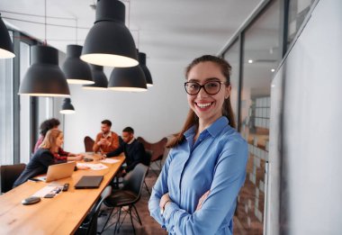 Modern ofis ortamında, sarışın bir iş kadını, stratejik tartışmalar ve karar verme sürecinde meslektaşlarıyla bir toplantı düzenler.. 