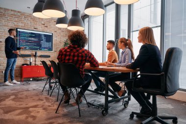 Kurumsal bir ortamda, Afrikalı-Amerikalı bir işadamı bir toplantıya liderlik eder, özenli ekibine tutkuyla bir iş planı sunar, işbirliği ve stratejik düşünmeyi teşvik eder.. 