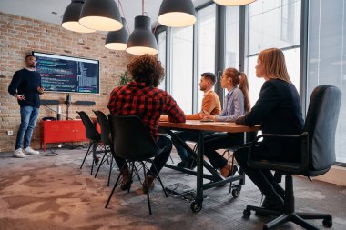 Kurumsal bir ortamda, Afrikalı-Amerikalı bir işadamı bir toplantıya liderlik eder, özenli ekibine tutkuyla bir iş planı sunar, işbirliği ve stratejik düşünmeyi teşvik eder.. 