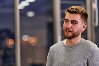 Yakın çekim, Avrupalı bir işadamını modern ofis ortamında iş arkadaşlarıyla derinden tartışırken yakalıyor..