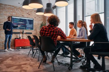 Kurumsal bir ortamda, Afrikalı-Amerikalı bir işadamı bir toplantıya liderlik eder, özenli ekibine tutkuyla bir iş planı sunar, işbirliği ve stratejik düşünmeyi teşvik eder.. 