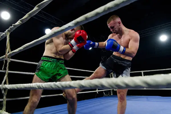 stock image Two skilled kickboxers engage in a fierce and technical exchange of kicks in a captivating display of athleticism and combat prowess. 