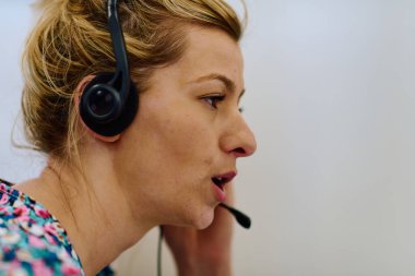 Bir kadın çağrı merkezi ajanının müşterilere özel destek ve yardım sağladığı, karşılaştıkları çeşitli sorunları çözmelerine yardımcı olduğu görülebilir.. 