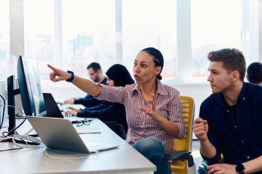 Ofiste yapılan beyin fırtınası sırasında çok kültürlü genç iş adamlarının ortak çalışma süreci. Resmi olarak giyinmiş çeşitli gençler tasarım projesinin geliştirilmesinde işbirliği yapıyor.