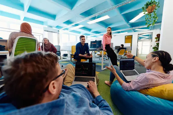 stock image In a modern startup office, a diverse group of young and capable businesspeople engage in lively discussions about various projects, showcasing teamwork, innovation, and entrepreneurial spirit. 