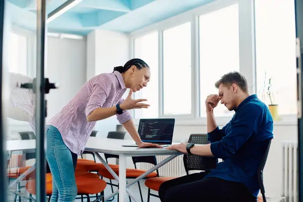 stock image A furious business director of a startup office berating her employee for business mistakes and errors. 