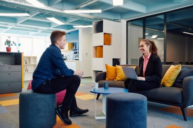 Çok ırklı bir girişim ekibi modern, açık alan çalışma ofisinde toplanıyor. Beyin fırtınası, dizüstü bilgisayarda çalışmak. Hareket bulanıklığı içinde dolaşan bir grup iş arkadaşı.