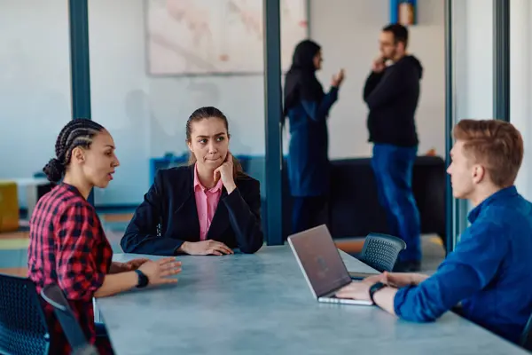 stock image A team of successful programmers sits in a startup office, strategizing new business projects and solving existing challenges, showcasing innovation and collaboration in the tech industry. 