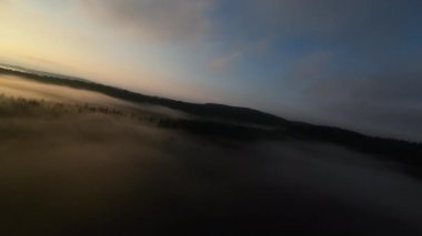 Puslu ormanda sabah sisli bir havada uçan hava aracı bulutların üzerinde gündoğumu rüyası konsepti