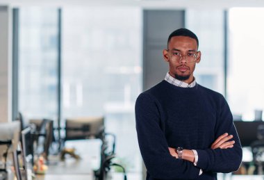  Afrikalı Amerikalı işadamı çapraz kollarla kendinden emin bir duruş sergiliyor, kararlılığı ve liderliği somutlaştırıyor