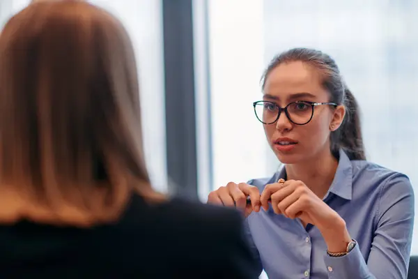 stock image A determined businesswoman confidently leads a meeting with colleagues, strategizing and discussing various business projects and challenges.