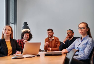 Girişimcilerden oluşan çeşitli bir iş ekibi, modern ofis ortamında önemli bir toplantı düzenliyor ve projeler geliştiriyor..