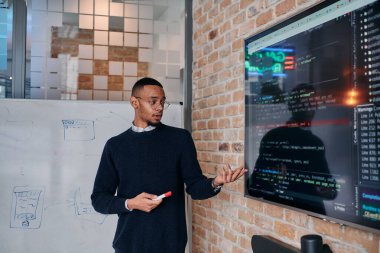 Afrikalı Amerikalı iş adamı iş stratejisini meslektaşlarına sunuyor, işbirliğini ve ileriyi düşünmeyi teşvik ediyor..