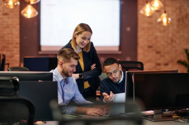 Çağdaş bir ofis ortamında, çeşitli iş adamları iş girişimlerini strateji haline getirmek ve planlamak için bilgisayarları kullanarak odaklanmış bir tartışmaya girişirler.. 