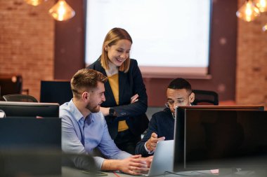 Çağdaş bir ofis ortamında, çeşitli iş adamları iş girişimlerini strateji haline getirmek ve planlamak için bilgisayarları kullanarak odaklanmış bir tartışmaya girişirler.. 