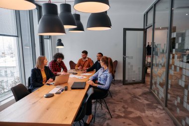 Girişimcilerden oluşan çeşitli bir iş ekibi, modern ofis ortamında önemli bir toplantı düzenliyor ve projeler geliştiriyor..