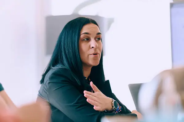 stock image Capturing the essence of leadership and collaboration, this headshot portrait showcases a professional businesswoman attentively guiding a productive meeting with colleagues, exuding confidence and