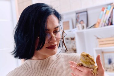 A young woman poses with her two pets, a bearded dragon and a stick insect, in this heartwarming photo. clipart