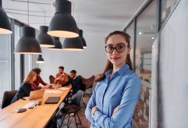 Modern ofis ortamında, sarışın bir iş kadını, stratejik tartışmalar ve karar verme sürecinde meslektaşlarıyla bir toplantı düzenler.. 