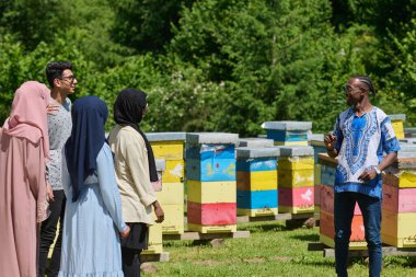 A diverse group of young friends and entrepreneurs explore small honey production businesses in the natural setting of the countryside clipart